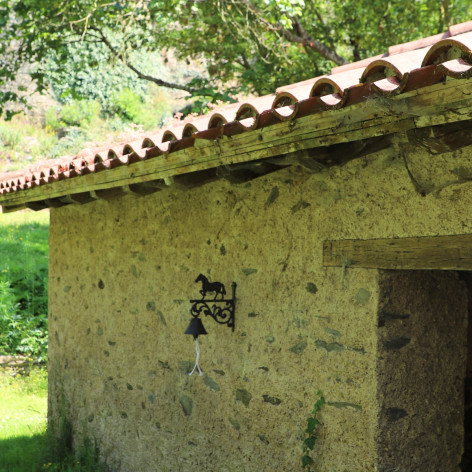 Cloche murale en fonte marron surmontée d'un cheval